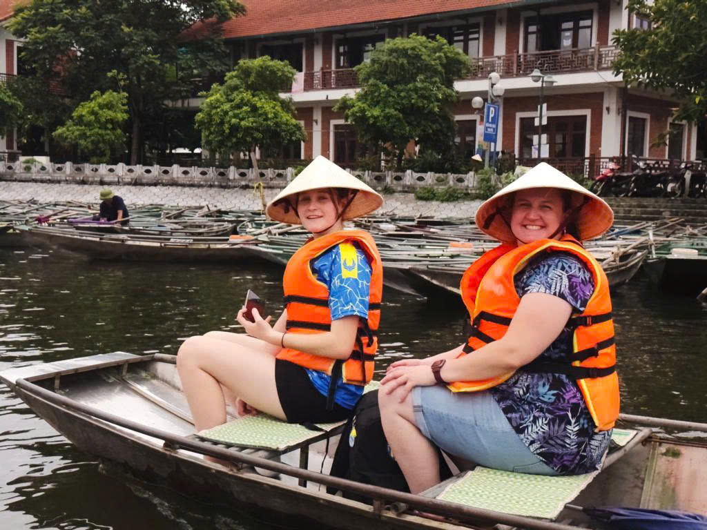 Tourists enjoying a traditional sampan boat ride in Tam Coc Ninh Binh